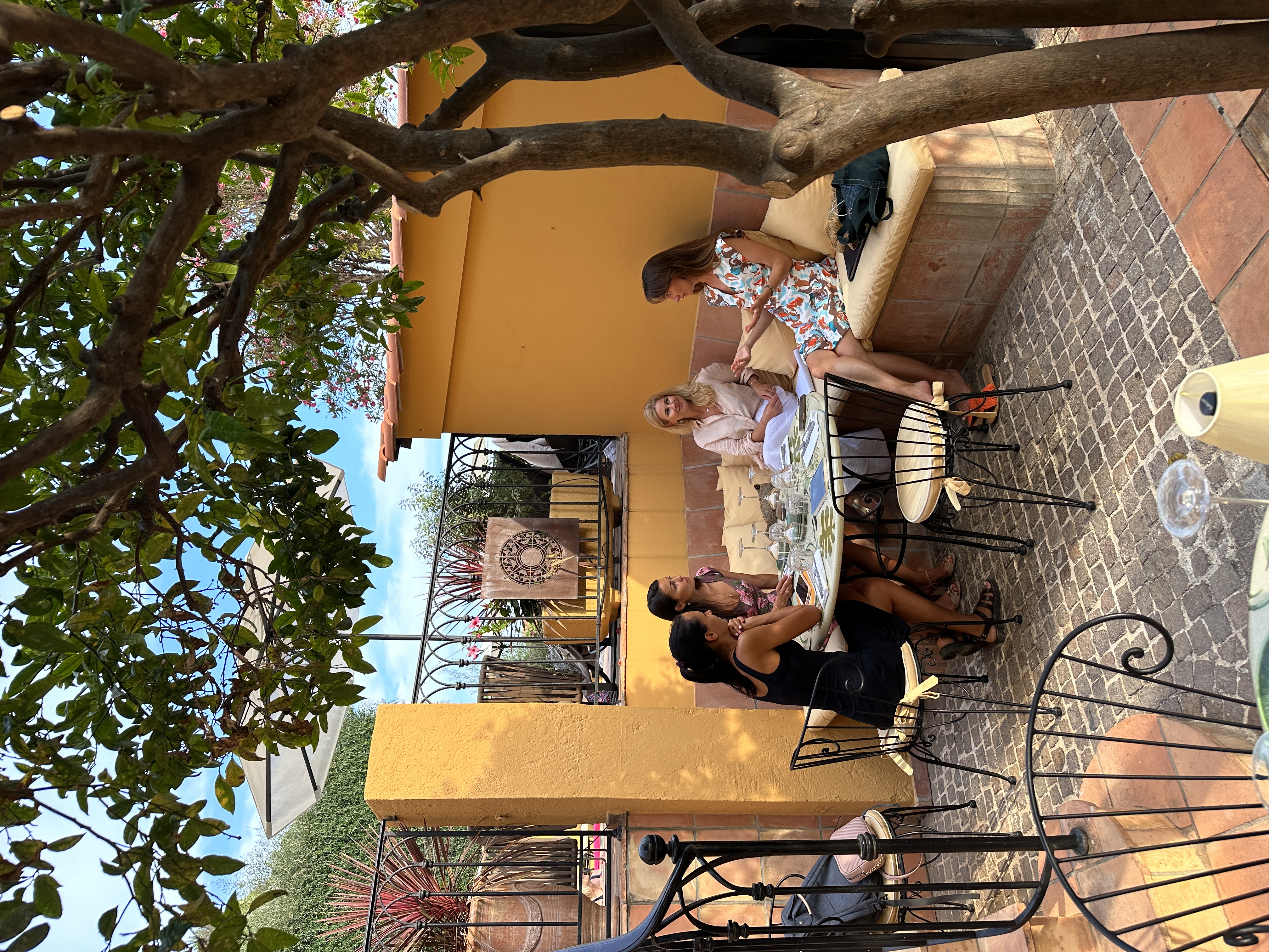A small mastermind group in conversation in a courtyard
